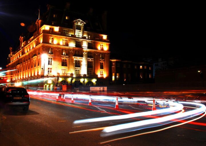 Los beneficios básicos de la experiencia hotelera transferible 2 un automóvil conduciendo por una calle de la ciudad por la noche