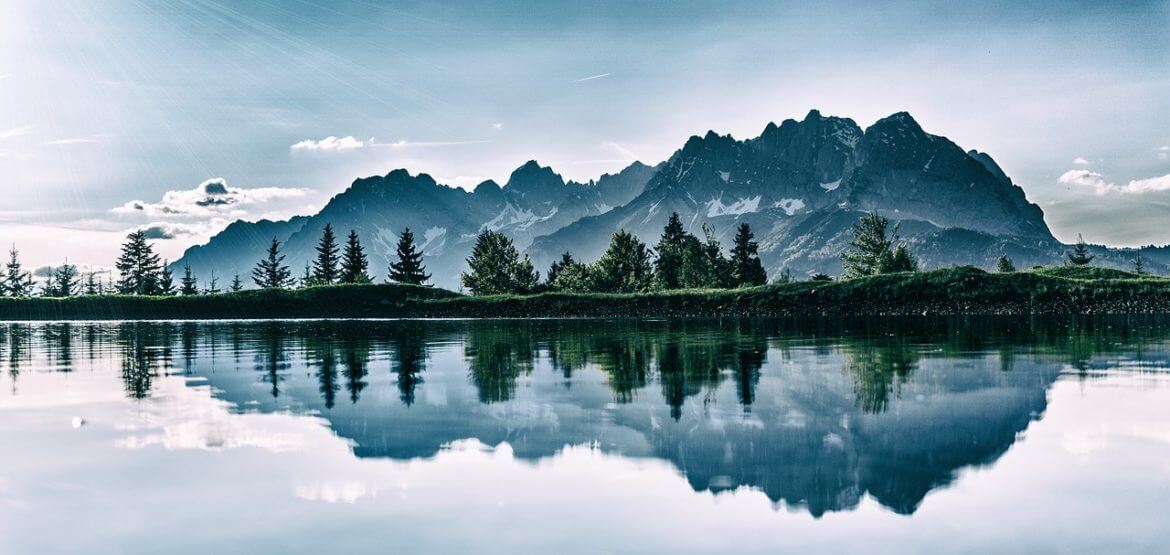 a mountain range is reflected in the water