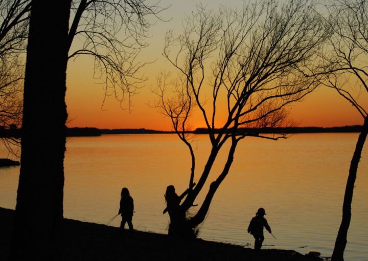 Prueba de empleo de niñera: evaluación de las mejores opciones de niñeras 10 tres personas caminando por la orilla de un lago al atardecer