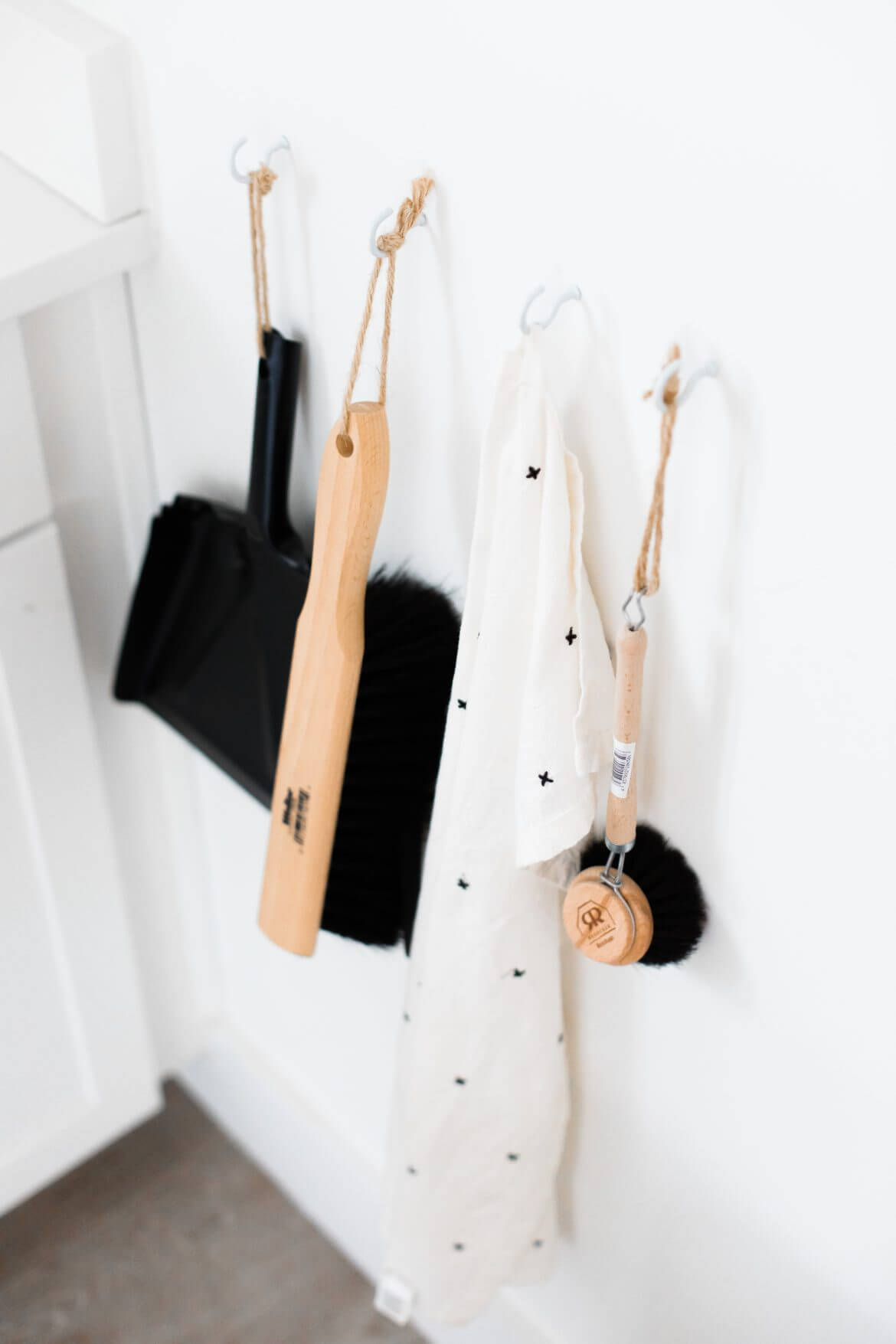 three coats hang on the wall with hooks