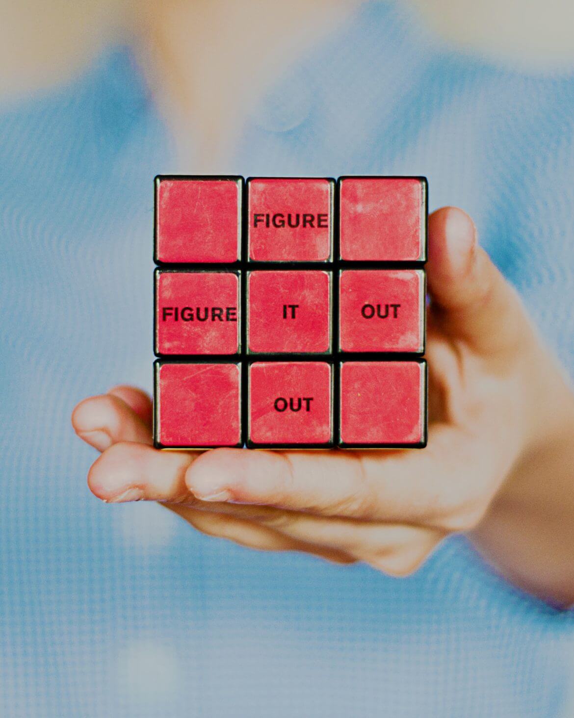 a person holding a cube with words on it