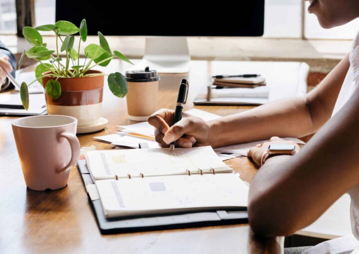 1 Diferencia fundamental entre un asistente ejecutivo y un asistente personal 2 dos personas sentadas en un escritorio con cuadernos y bolígrafo